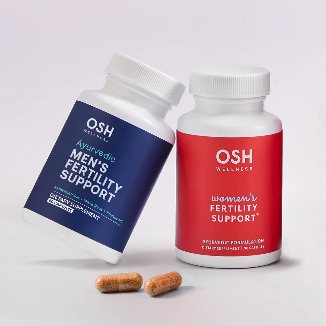 Two bottles of fertility support supplements for men and women and two loose capsules.