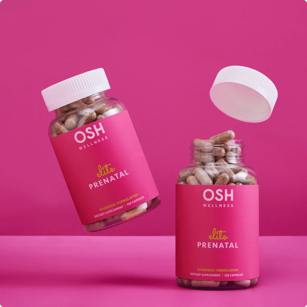 Two pink OSH Wellness Elite Prenatal bottles, one floating, with capsules and a white cap.