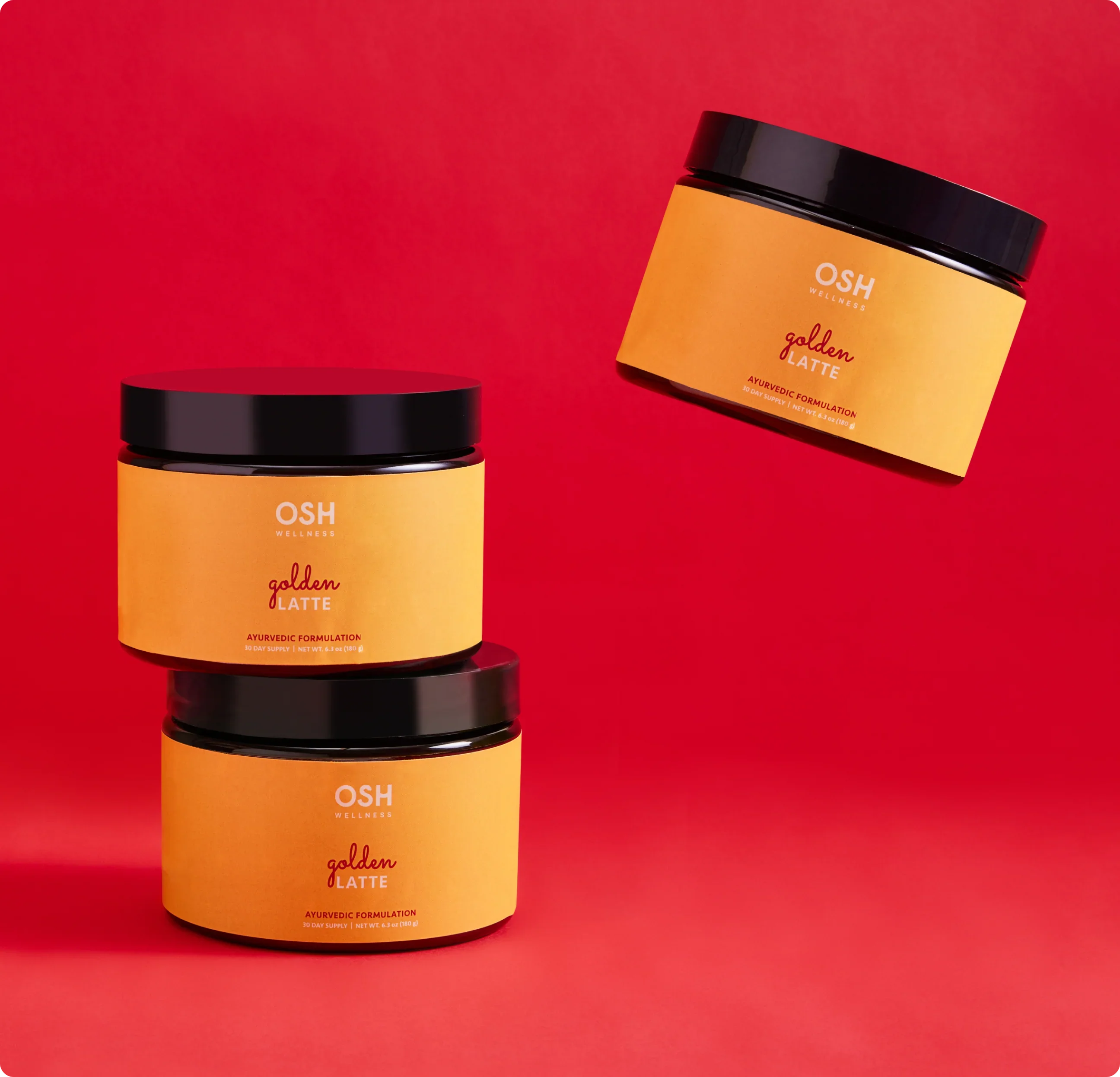 Three jars of OSH Wellness golden latte on a red background.