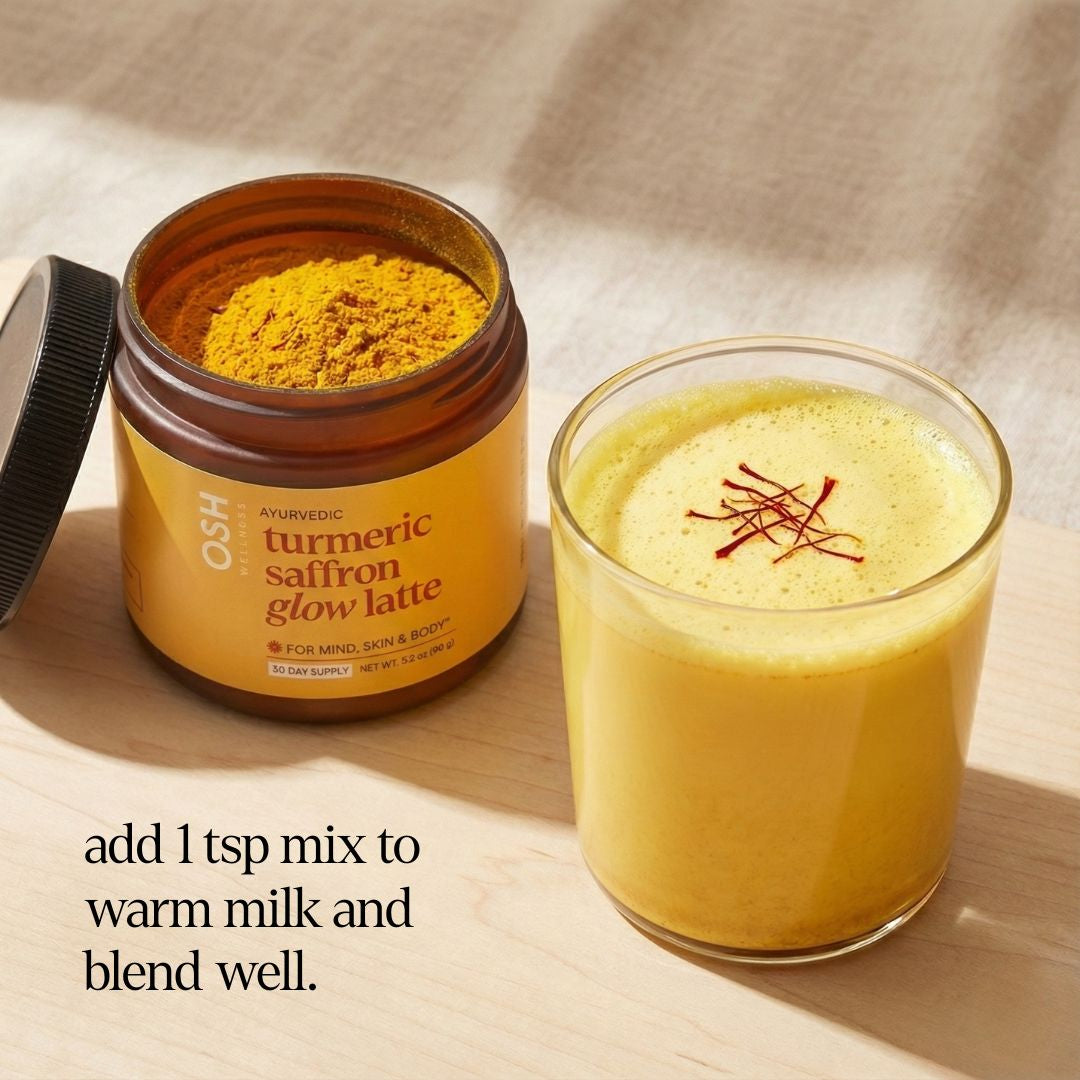 Jar of Osh Ayurvedic turmeric saffron glow latte mix next to a glass of the prepared drink on a wooden surface.