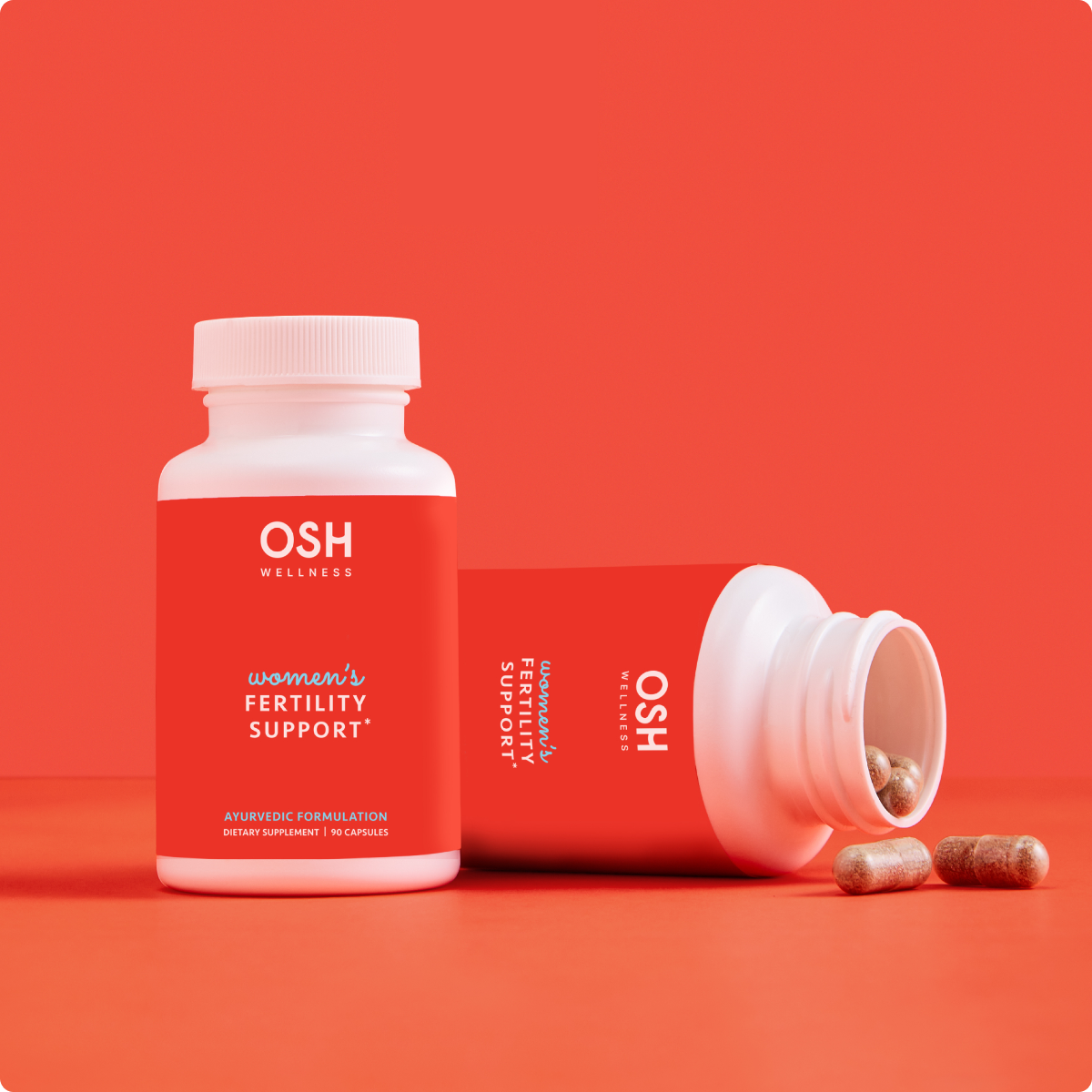 A bottle of Osh Wellness Women's Fertility Support supplements with the label facing forward, showing the brand name and product title, with several capsules spilling out in front of a red background.